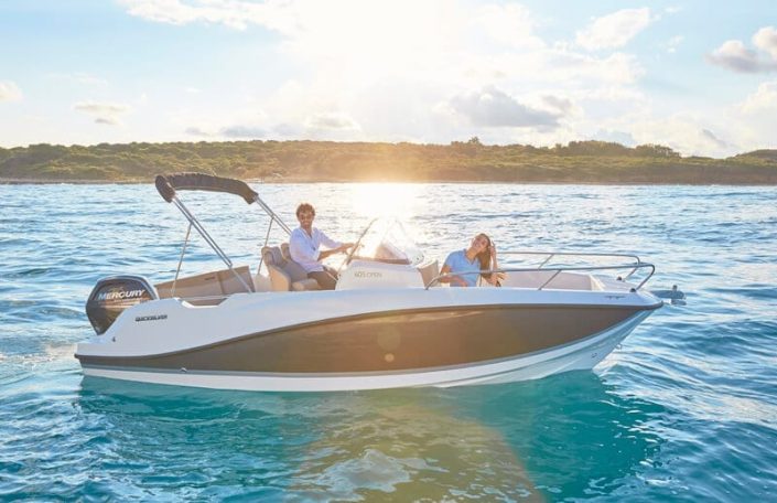 Pareja navegando y disfrutando en quicksilver 605 open.